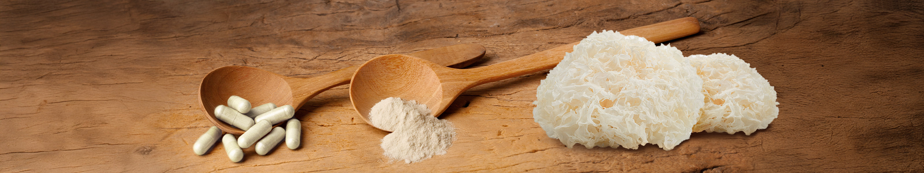 Vitalpilz Tremella mit Kapseln und Pulver auf einem Holzlöffel