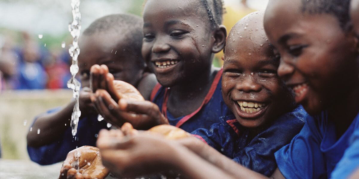 fröhliche Kinder mit fließendem Wasser